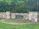 Stone community entrance with signage and manicured landscaping at 113 Ruskin Dr, Chapel Hill, NC 27516