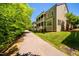 View of the exterior of the condo buildings, showcasing the walking trail alongside landscaped lawn at 113 Ruskin Dr, Chapel Hill, NC 27516