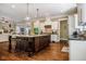 Open-concept kitchen featuring a center island with seating, pendant lights, and hardwood floors at 113 Ruskin Dr, Chapel Hill, NC 27516