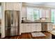 Bright kitchen featuring stainless steel appliances, granite countertops, and custom white cabinets at 113 Ruskin Dr, Chapel Hill, NC 27516