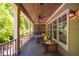Inviting outdoor porch featuring a dining table, ceiling fans, and a serene view of the surrounding landscape at 113 Ruskin Dr, Chapel Hill, NC 27516