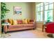 Cozy sitting room with a plush sofa, colorful artwork, and natural light from the window at 113 Ruskin Dr, Chapel Hill, NC 27516