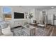 Open-concept living room with modern decor, hardwood floors, and plenty of natural light at 115 N Chubb Rdg, Wilson's Mills, NC 27520