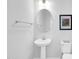 Elegant powder room with pedestal sink, oval mirror, and decorative artwork adds charm to this modern home at 11549 Helmond Way # 107, Raleigh, NC 27617