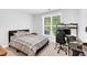 Inviting bedroom with a window view, desk area, and neutral-toned bedding creating a relaxing atmosphere at 11549 Helmond Way # 107, Raleigh, NC 27617