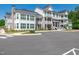 Beautiful condo building with multiple balconies, brick accents, and well-manicured landscaping at 11549 Helmond Way # 107, Raleigh, NC 27617