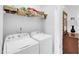 Functional laundry room with washer, dryer, and shelving offering convenient organization and storage at 11549 Helmond Way # 107, Raleigh, NC 27617
