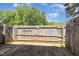 View of a fenced backyard from wood deck with a wooden fence under a blue sky with scattered clouds at 1223 Jamestown Ct, Cary, NC 27511