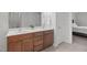 Bathroom featuring double sinks, a decorative plant, wood cabinets, and a doorway at 124 Willa Chase Ct, Benson, NC 27504