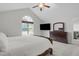 Bright main bedroom featuring a vaulted ceiling, ceiling fan, large window, and ensuite bathroom at 124 Willa Chase Ct, Benson, NC 27504