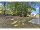 A view of the backyard, showing a partially wooded lot and a concrete patio at 129 Davis St, Louisburg, NC 27549