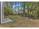 A view of the backyard, showing a partially wooded lot with a concrete patio at 129 Davis St, Louisburg, NC 27549
