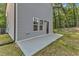 A view of the side of the house, showcasing a concrete patio and back door at 129 Davis St, Louisburg, NC 27549