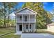 Charming two-story home with a welcoming front porch and neutral gray siding at 129 Davis St, Louisburg, NC 27549