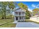 Charming two-story home with double porch, landscaped yard, and concrete driveway at 129 Davis St, Louisburg, NC 27549