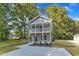 Charming two-story home with double porch, landscaped yard, and concrete driveway at 129 Davis St, Louisburg, NC 27549