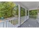 View from the porch shows the surrounding trees and a distant street at 129 Davis St, Louisburg, NC 27549