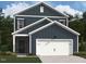 Charming two-story home featuring a white garage door and stone entryway, set against a backdrop of lush greenery at 1410 Malcus Ct # 55, Fuquay Varina, NC 27526