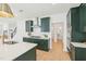 Modern kitchen with dark green cabinets, stainless steel appliances, and a sleek white countertop at 1410 Malcus Ct # 55, Fuquay Varina, NC 27526