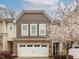 Charming townhome with stone accents, a two-car garage, and a beautiful blooming tree in the front yard at 149 Wards Ridge Dr, Cary, NC 27513