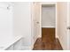 Well-lit hallway with hardwood floors, a built-in bench, and multiple doorways leading to various rooms at 149 Wards Ridge Dr, Cary, NC 27513