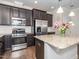 Contemporary kitchen with granite countertops, stainless appliances, and dark wood cabinetry at 149 Wards Ridge Dr, Cary, NC 27513