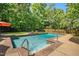 A backyard pool surrounded by lush landscaping, fenced in and complete with concrete patio surrounding it at 150 Georgetown Woods Dr, Youngsville, NC 27596