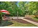 Inviting backyard pool surrounded by lush trees, featuring colorful umbrellas and poolside seating at 150 Georgetown Woods Dr, Youngsville, NC 27596