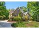 An exterior side view of a brick home surrounded by verdant landscaping and a driveway at 150 Georgetown Woods Dr, Youngsville, NC 27596