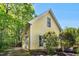 View of the house showing the garage and side yard, with lush greenery and mature trees offering privacy at 150 Georgetown Woods Dr, Youngsville, NC 27596
