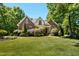 Stunning brick home featuring manicured lawn, mature trees, and attractive landscaping at 150 Georgetown Woods Dr, Youngsville, NC 27596