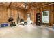 Spacious garage with plywood walls, concrete floor, shelving, and storage for organizing tools and equipment at 150 Georgetown Woods Dr, Youngsville, NC 27596