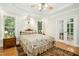 Large main bedroom with a ceiling fan, wood floors, and a side table at 150 Georgetown Woods Dr, Youngsville, NC 27596