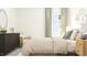 Bedroom with a large window, neutral bedding, and modern decor on the dresser at 1548 Bright Coral Trl, Wendell, NC 27591