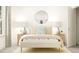 Bright bedroom featuring a round mirror, neutral colors, and bedside tables with lamps at 1548 Bright Coral Trl, Wendell, NC 27591