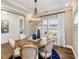 Chic dining room with wood table, modern chandelier, and large windows with bright light at 1556 Bright Coral Trl, Wendell, NC 27591