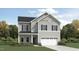 Charming two-story home showcasing light gray siding, black shutters, and an attached two-car garage at 1556 Bright Coral Trl, Wendell, NC 27591