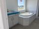 Bathroom featuring a soaking tub with tile surround, vanity and abundant natural light at 1609 Malcus Ct # 67, Fuquay Varina, NC 27526