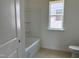 Bright bathroom features a white tub/shower combo and a window for natural light at 1609 Malcus Ct # 67, Fuquay Varina, NC 27526