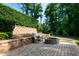 Charming backyard patio featuring a stone fire pit, retaining wall, and comfortable seating, perfect for outdoor relaxation at 1820 Yates Wheel Way, Raleigh, NC 27606