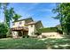 Scenic backyard featuring a wooden deck, stone patio, and mature trees, perfect for outdoor living and entertaining at 1820 Yates Wheel Way, Raleigh, NC 27606
