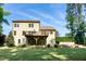 Backyard view showcasing a spacious deck, stone patio with firepit, and lush greenery creating a private outdoor oasis at 1820 Yates Wheel Way, Raleigh, NC 27606