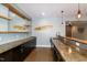 Basement bar with stylish countertops, dark cabinetry, and shelving at 1820 Yates Wheel Way, Raleigh, NC 27606