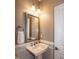 Compact bathroom with a pedestal sink, and silver framed mirror with towel hook at 1820 Yates Wheel Way, Raleigh, NC 27606