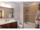 Bathroom with marble countertop, dark wood cabinets, framed mirror, a toilet and a shower and tub combination at 1820 Yates Wheel Way, Raleigh, NC 27606