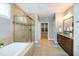 Large main bathroom with double sink vanity, a soaking tub, and a glass-enclosed shower with tile surround at 1820 Yates Wheel Way, Raleigh, NC 27606