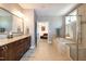 Luxurious primary bathroom featuring double vanity, soaking tub, glass enclosed shower, and access to the primary bedroom at 1820 Yates Wheel Way, Raleigh, NC 27606
