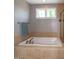 Large tub in primary bathroom under a window at 1820 Yates Wheel Way, Raleigh, NC 27606