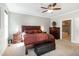 A well-lit bedroom features a ceiling fan, large bed and sitting bench at 1820 Yates Wheel Way, Raleigh, NC 27606