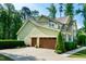 Two-story home with a three car garage and landscaped front yard, offering curb appeal and functionality at 1820 Yates Wheel Way, Raleigh, NC 27606